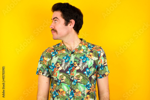 Wallpaper Mural Side view of young happy smiling young handsome Caucasian man wearing Hawaiian shirt against yellow wall Torontodigital.ca