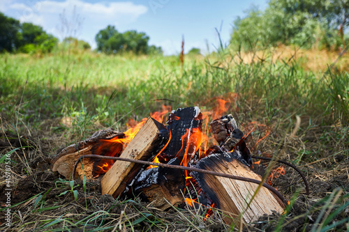 Burning bonfire firewood, in nature, place for barbecue, barbecue in a summer meadow