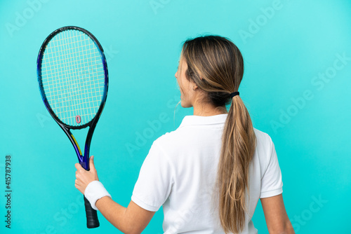 Young caucasian woman isolated on blue background playing tennis and celebrating a victory © luismolinero