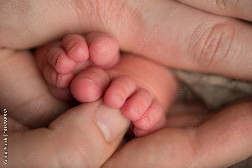 Loving parent hold baby's legs. Happy childhood. Parental care. Concept of a happy family. Loving parent hold baby's legs. Happy childhood. Parental care. Concept of a happy family.