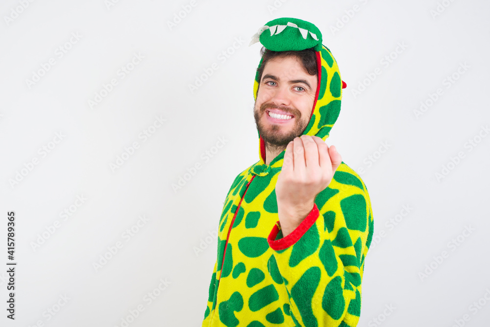 Fototapeta premium young caucasian man wearing a pajama standing against white wall inviting to come with hand. Happy that you came