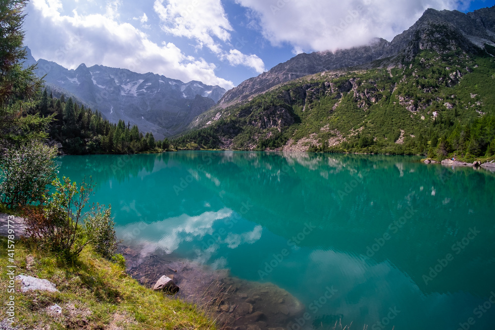 Rocky peaks reflected in Lago Aviolo, Lombardy, Italy. Clear turquoise water in alpine mountain lake. Rocky peaks reflected in Lago Aviolo, Lombardy, Italy. Clear turquoise water in alpine mountain lake.