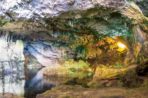 Wide view of cave hall with underground lake and stalactite decoration, Grotte di Nettuno (Nettuno caves), Sardinia, Italy. photo