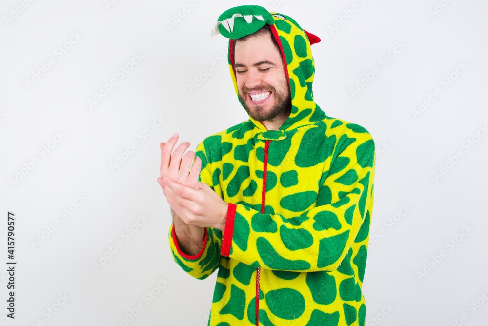 Fototapeta premium young caucasian man wearing a pajama standing against white wall Suffering pain on hands and fingers, arthritis inflammation