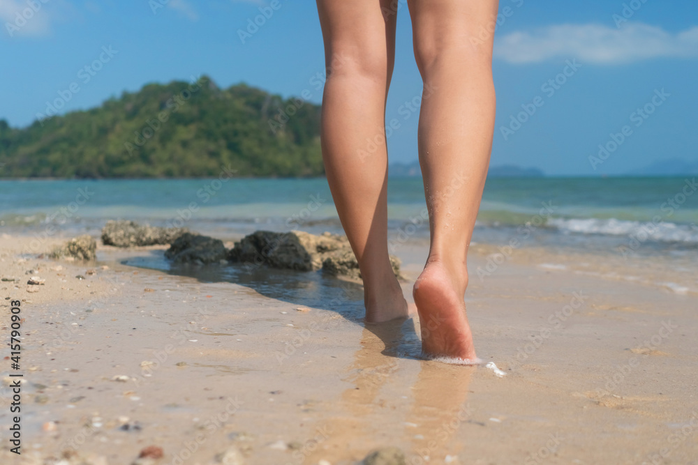 Woman feet walk slow life and relax on sand tropical beach with blue sky background. Woman feet walk slow life and relax on sand tropical beach with blue sky background.