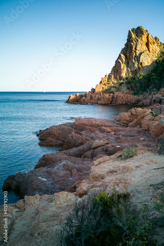 Coastal rocks formed for years by crashing waves. Jagged sea coast lit by first sun rays of day, Sardinia, Italy.