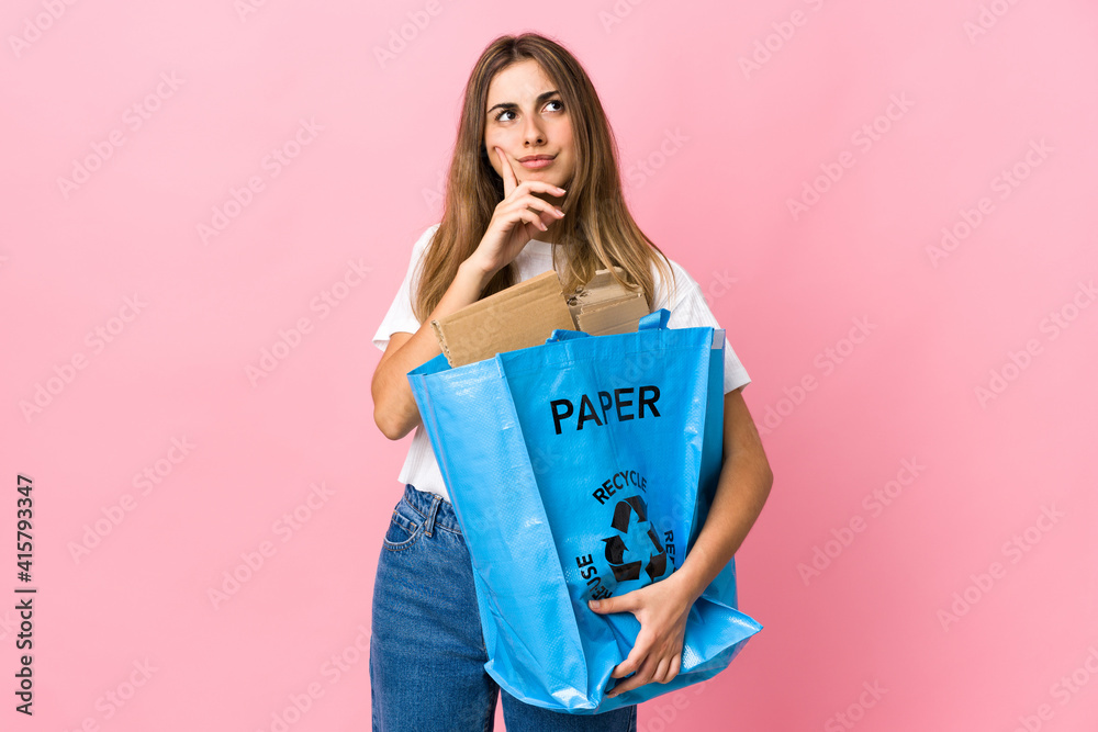 holding a recycling bag full of paper to recycle over isolated pink thinking an idea holding a recycling bag full of paper to recycle over isolated pink thinking an idea