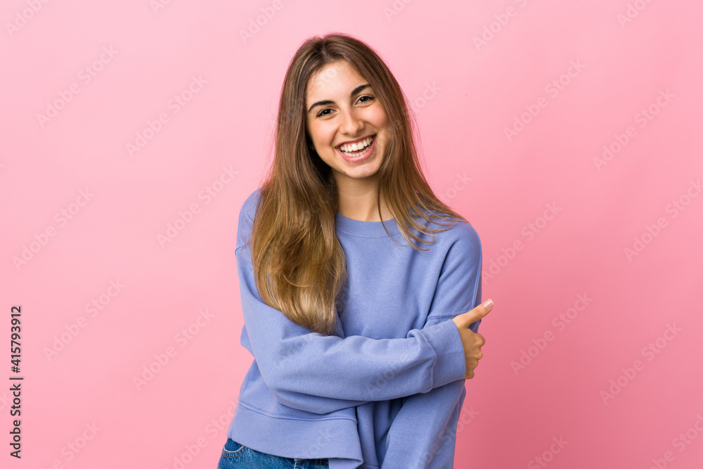 Fototapeta premium Young woman over isolated pink background laughing