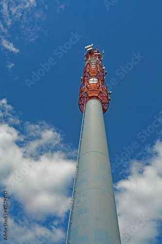 High transmitter mast in the blue sky.