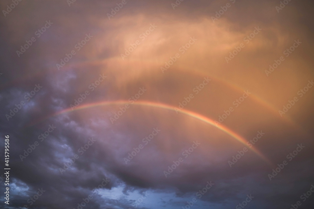 Fototapeta premium two rainbows in the dark sky at sunset