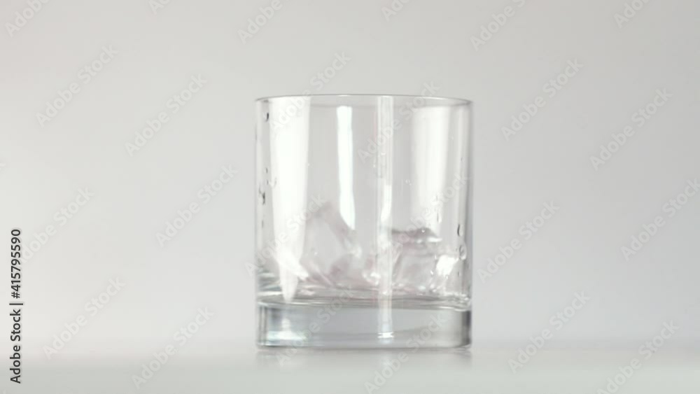 ice cubes falling into glass and splashing water. High quality footage ice cubes falling into glass and splashing water. High quality footage
