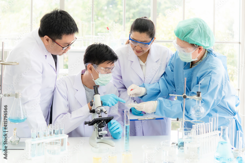 Team work asian woman and man Scientists analyzing study data and evaluating microscope success for work shop. Health care researchers doing some research with dropper chemical testing Team work asian woman and man Scientists analyzing study data and evaluating microscope success for work shop. Health care researchers doing some research with dropper chemical testing