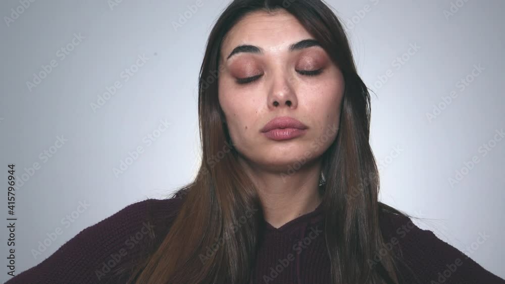 Young attractive woman taking a bored demeanor on gray background. Young attractive woman taking a bored demeanor on gray background.