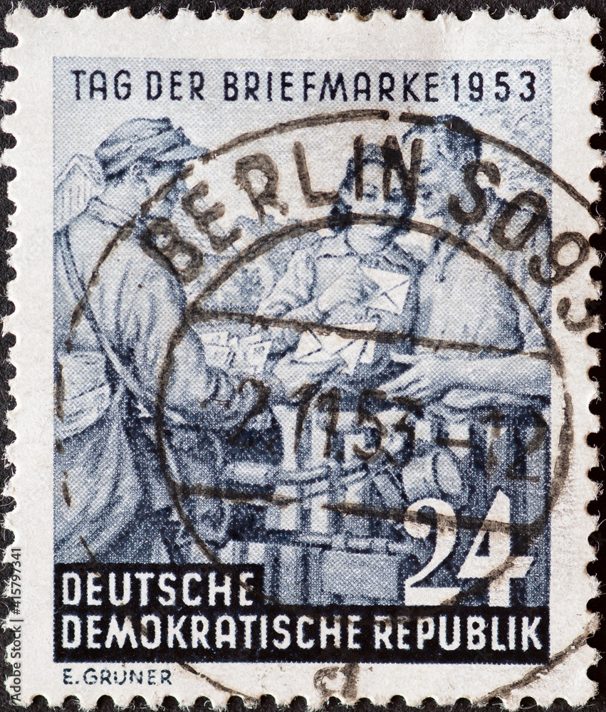 GERMANY, DDR - CIRCA 1953 : a postage stamp from Germany, GDR showing a country deliverer with bicycle hands over mail. Text: Stamp Day