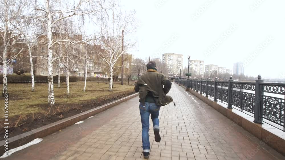 man runs hurries down the street of the city