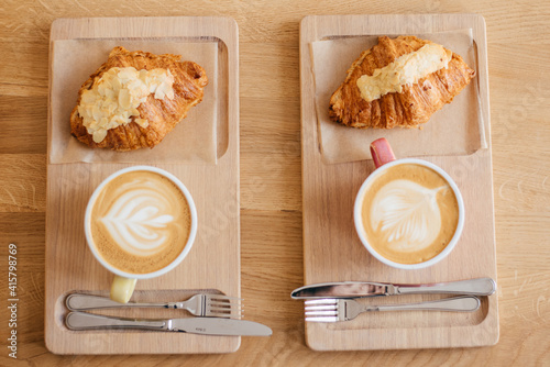 Fotografija Tasty croissants with jot coffee on wooden background