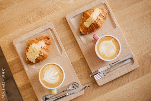 Canvastavla Tasty croissants with jot coffee on wooden background