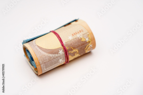 Roll of many euro money and bow isolated on white background