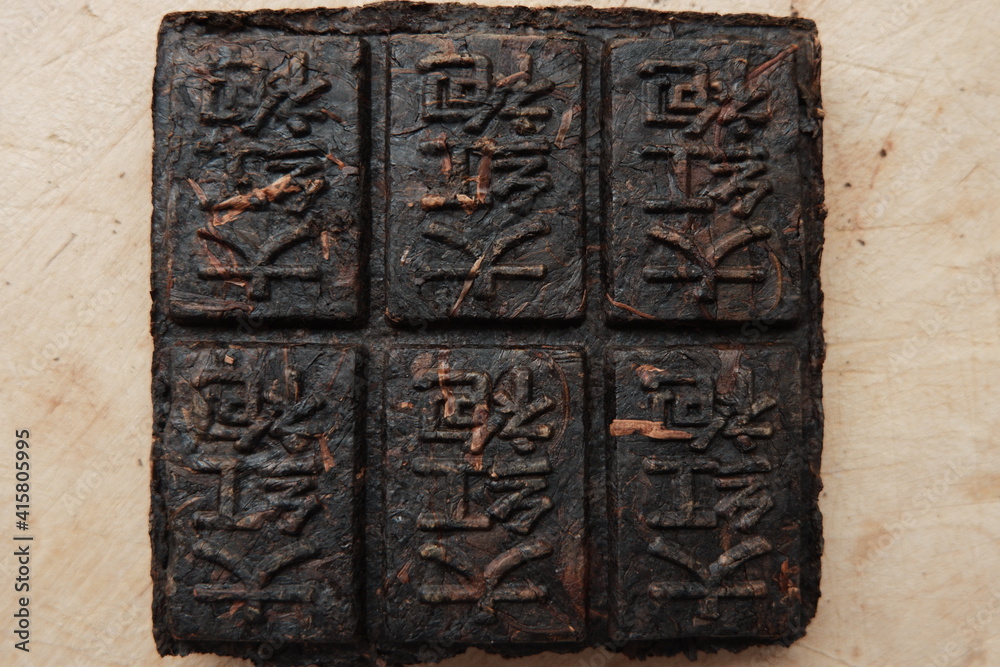 Pressed tea with hieroglyphs. Black Tiled Puerh Tea. Translation: 