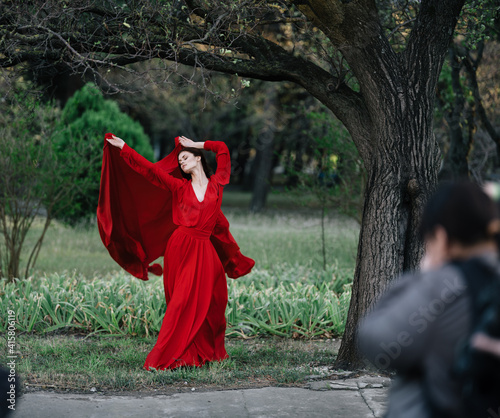 Woman in red dress near a tree posing in nature