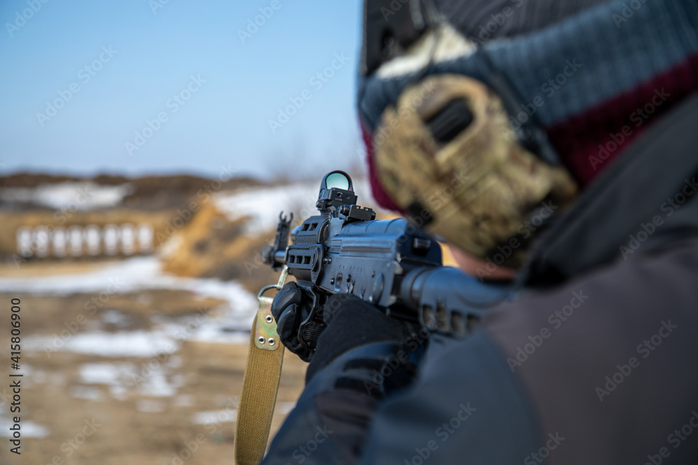 The shooter aims with a collimator from an automatic rifle, in the ...