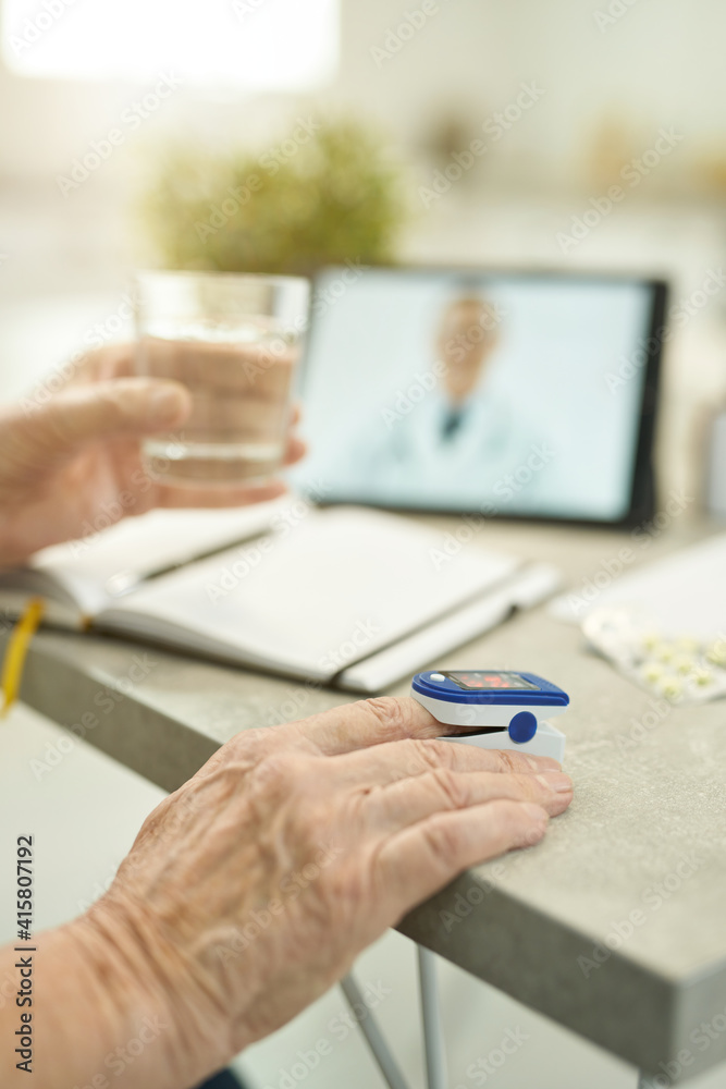 Senior citizen measuring vitals and consulting doctor online from home Senior citizen measuring vitals and consulting doctor online from home