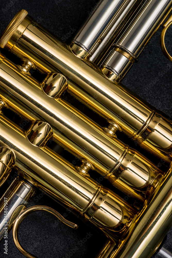 Naklejka premium Close up of the valves of a trumpet on a black background. Details of a trumpet
