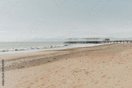 Meer  Wellen  leichte Wolken und Berge am Horizont  Sandstrand