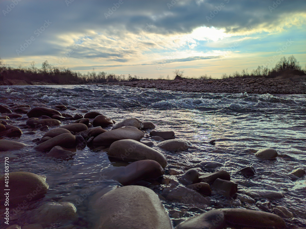 Landscape of a mountain river with stones on the shore and a beautiful sky. Landscape of a mountain river with stones on the shore and a beautiful sky.