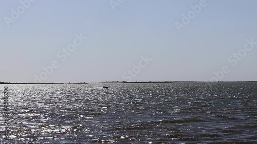 Silhouetted man jumping while kite boarding in near Corpus Christi Texas; kite surfing