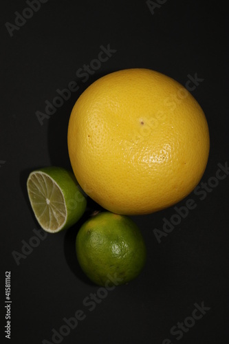 Fototapeta Naklejka Na Ścianę i Meble -  Grapefruit, orange, lemon and lime isolated on a black background. Citrus fruits in the section. Citrus slices. Still life of fruit.