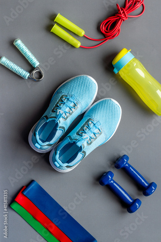 Fitness and gym equipment with sneakers and dumbbells. Sport background