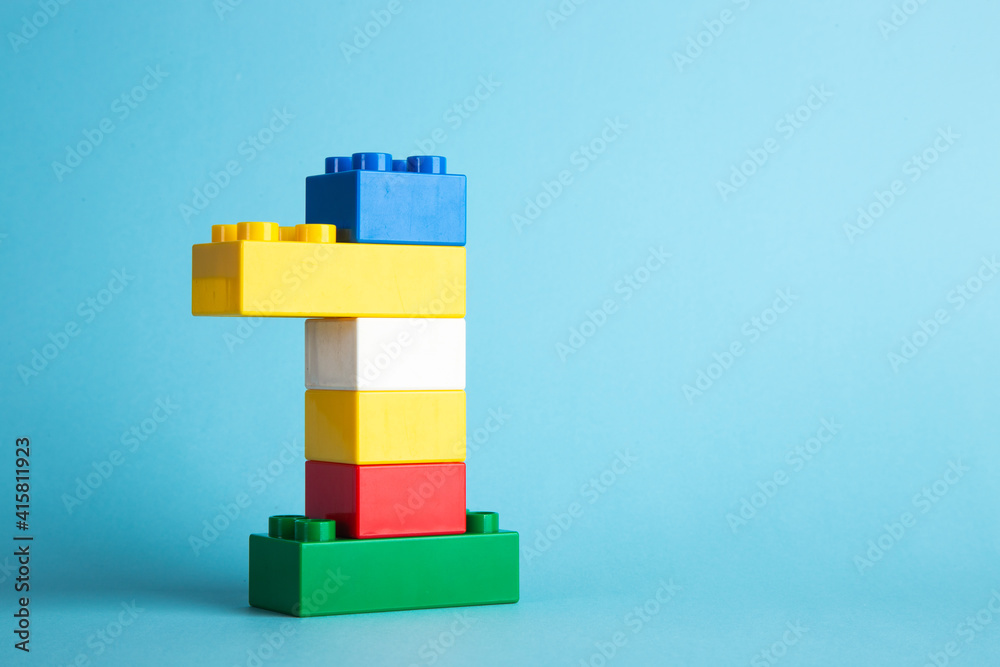 Obraz premium Color plastic building blocks on blue background