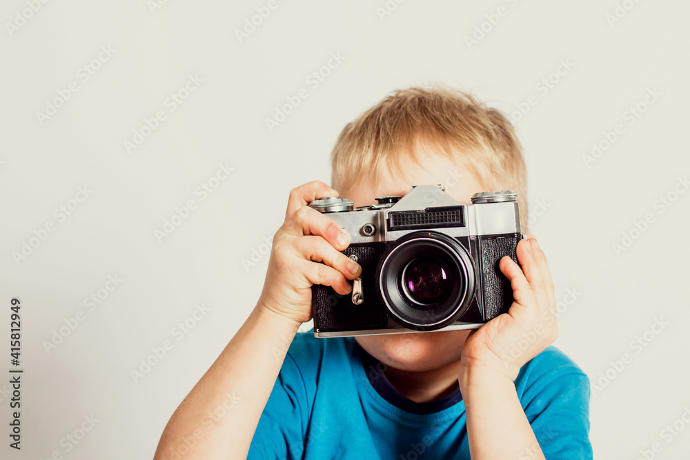 Little boy taking photo with old film camera. Retro technology concept with copy space. Little boy taking photo with old film camera. Retro technology concept with copy space.
