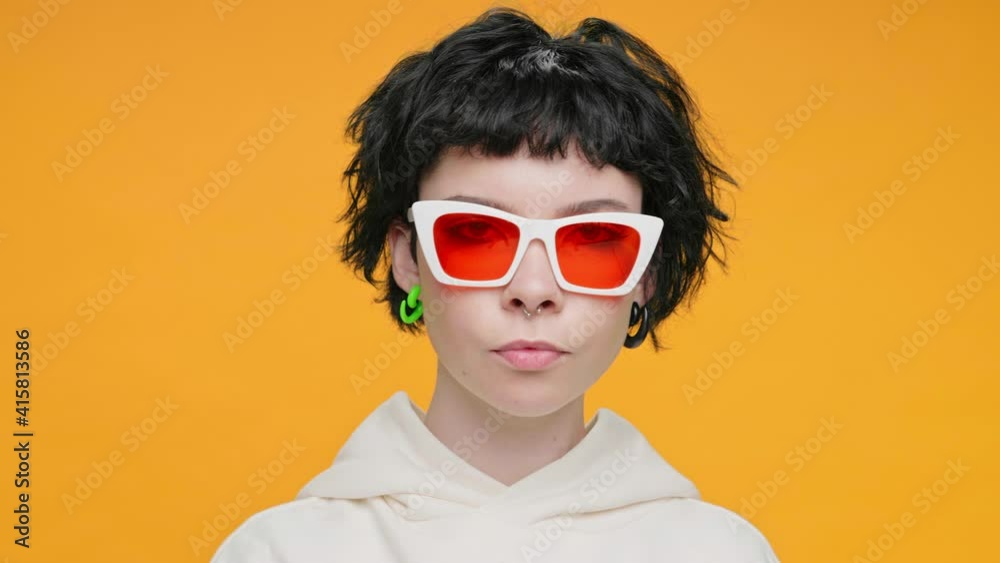 Happy Teenage Girl Dancing and Singing on Yellow Background with Piercings, Smiling, Rhythmically Moving her Hands Thumbs Up in Front of Camera Funny Slow Motion Dancing. Positive Emotions. Freedom Happy Teenage Girl Dancing and Singing on Yellow Background with Piercings, Smiling, Rhythmically Moving her Hands Thumbs Up in Front of Camera Funny Slow Motion Dancing. Positive Emotions. Freedom