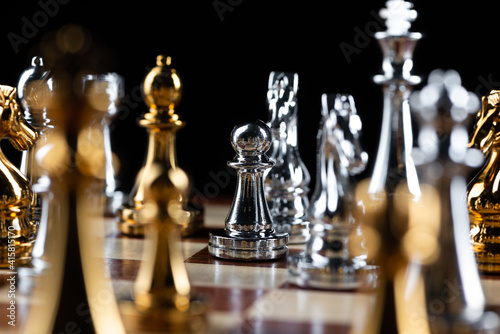 Gold and silver chess figures on chessboard