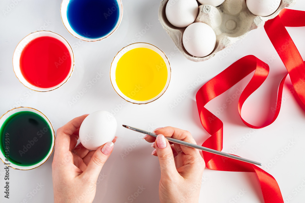 Young woman paints white eggs for easter. Young woman paints white eggs for easter.