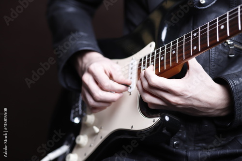 Dłonie gitarzysty na gryfie gitary elektrycznej