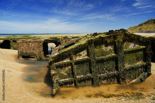 The iron elements of the boat are covered with rust and algae on the ocean shore. Environmental pollution.    