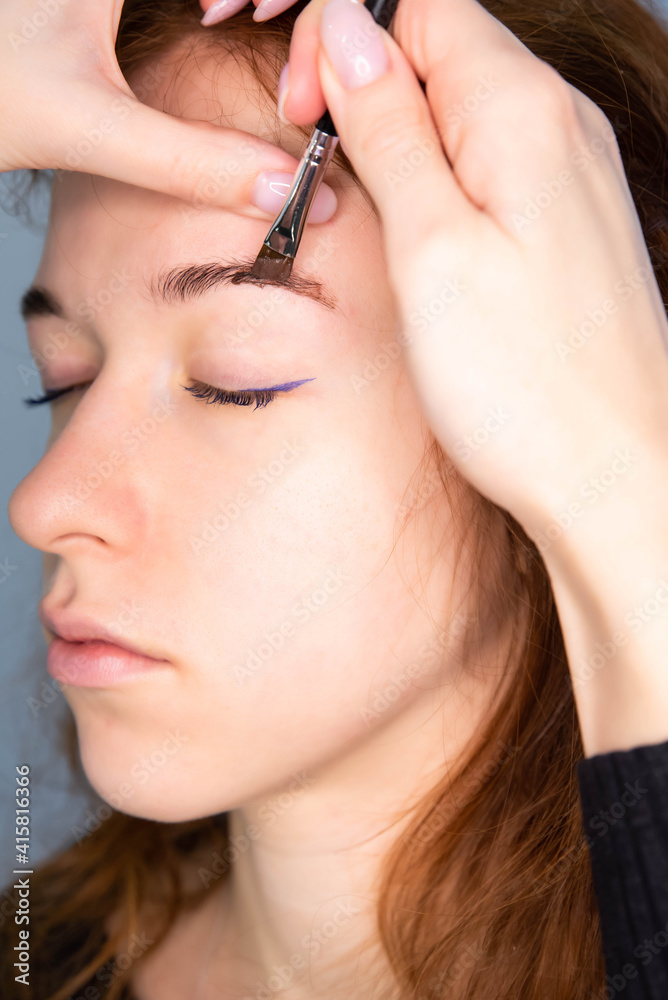 Fototapeta premium Young Caucasian Woman on the brow beauty procedures. Professional care for face. Brows coloring, wax and lamination. 