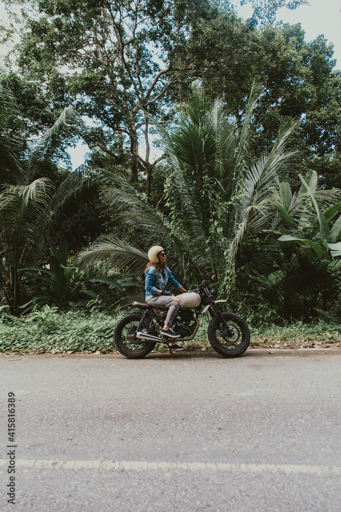 Beautiful girl having fun driving her custom cafe racer motorcycle Beautiful girl having fun driving her custom cafe racer motorcycle