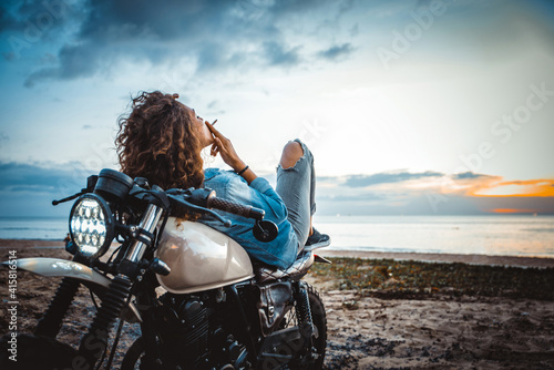 Canvas-taulu Beautiful girl having fun driving her custom cafe racer motorcycle, enjoying the