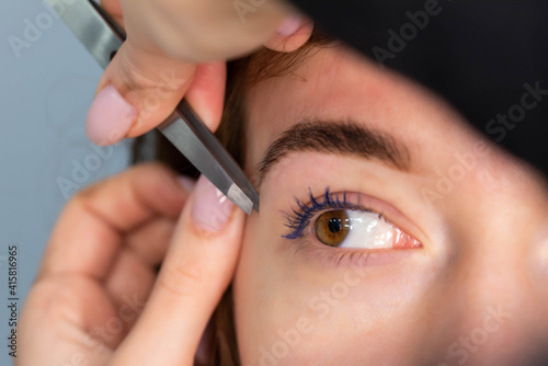 Young Caucasian Woman on the brow beauty procedures. Professional care for face. Brows coloring, wax and lamination. 