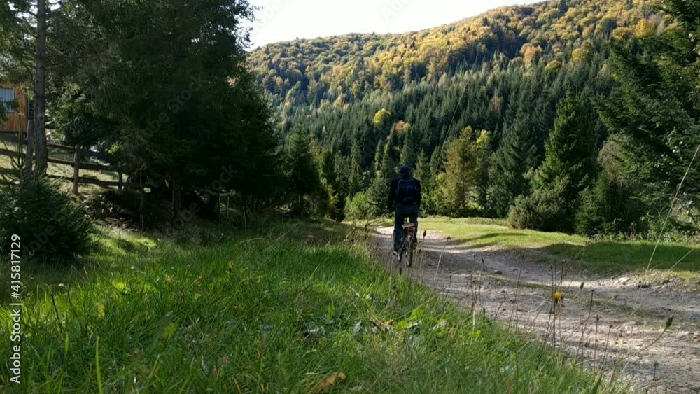 The bicycler running downhill in wild mountain terrain. The bicycler running downhill in wild mountain terrain.