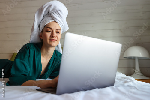 Young woman working at the computer after a shower