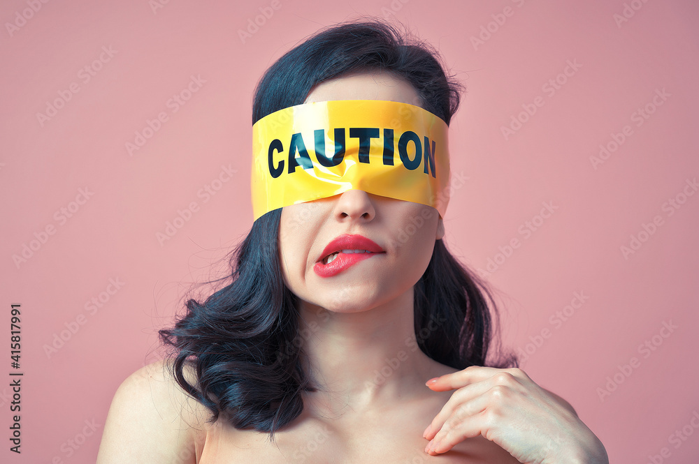 Cinematic image of a woman with a yellow tape on her face. Abstract