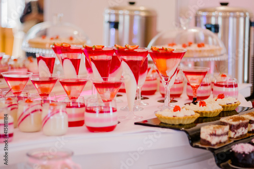 Wedding candy bar full of red and white desserts on a white table © Natalia Nakonechna