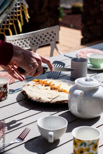 cutting vegan cake for outdoors tea time 
