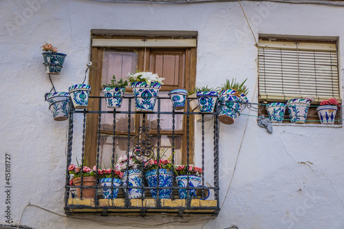 Cute facade and window with flower pots in the Albaicin historic district in Granada, Andalusia, Spain photo