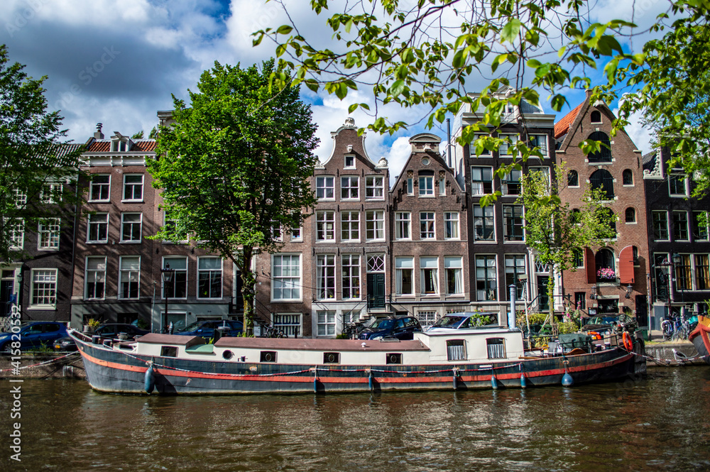 Amsterdam, Netherlands - July 7, 2019: A traditional Dutch houseboat in the canal of Amsterdam, the Netherlands